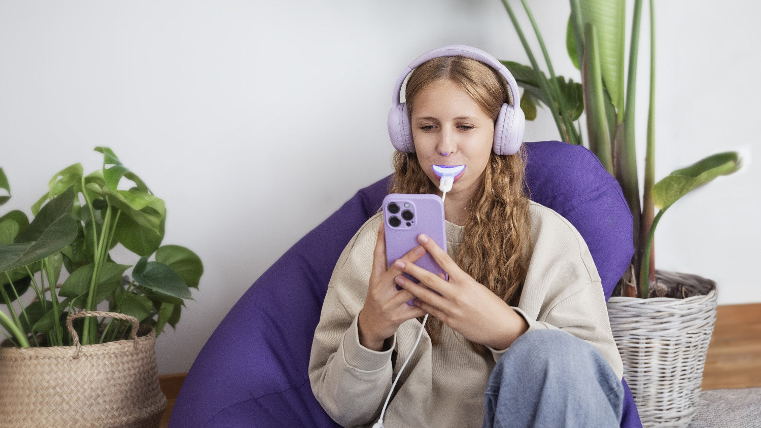 Tiener gebruikt Lumoral in woonkamer, ontspannen met telefoon, gericht op welzijn.