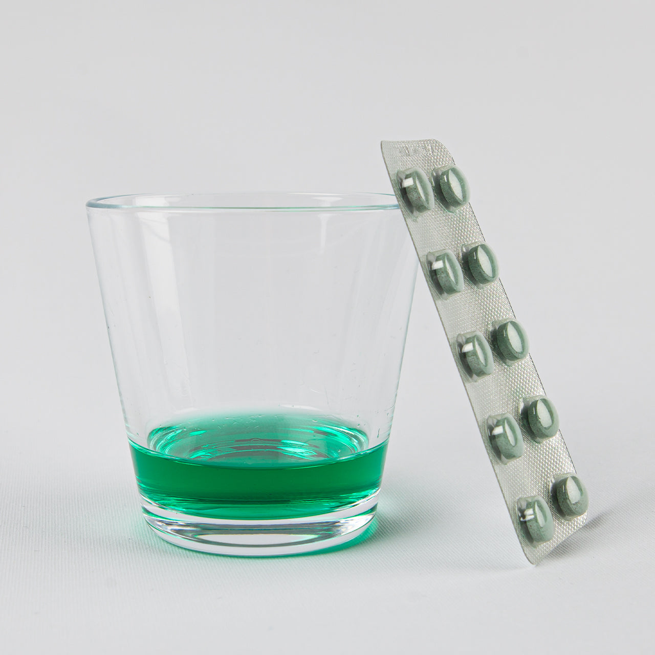 Glas water met een lumorinse tablet opgelost dat je moet leegdrinken