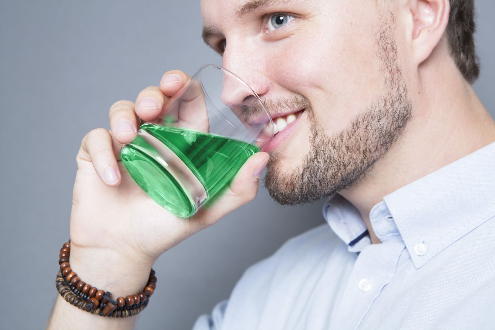 jonge heer die drinkt van het lumorinse drankje. het drankje is groen.