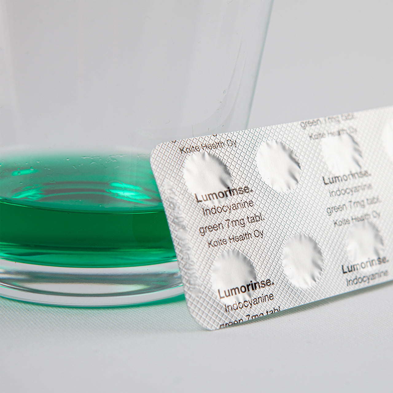 glas water met inhoud van één tablet met daarnaast de verpakking van de lumorinse tabletten